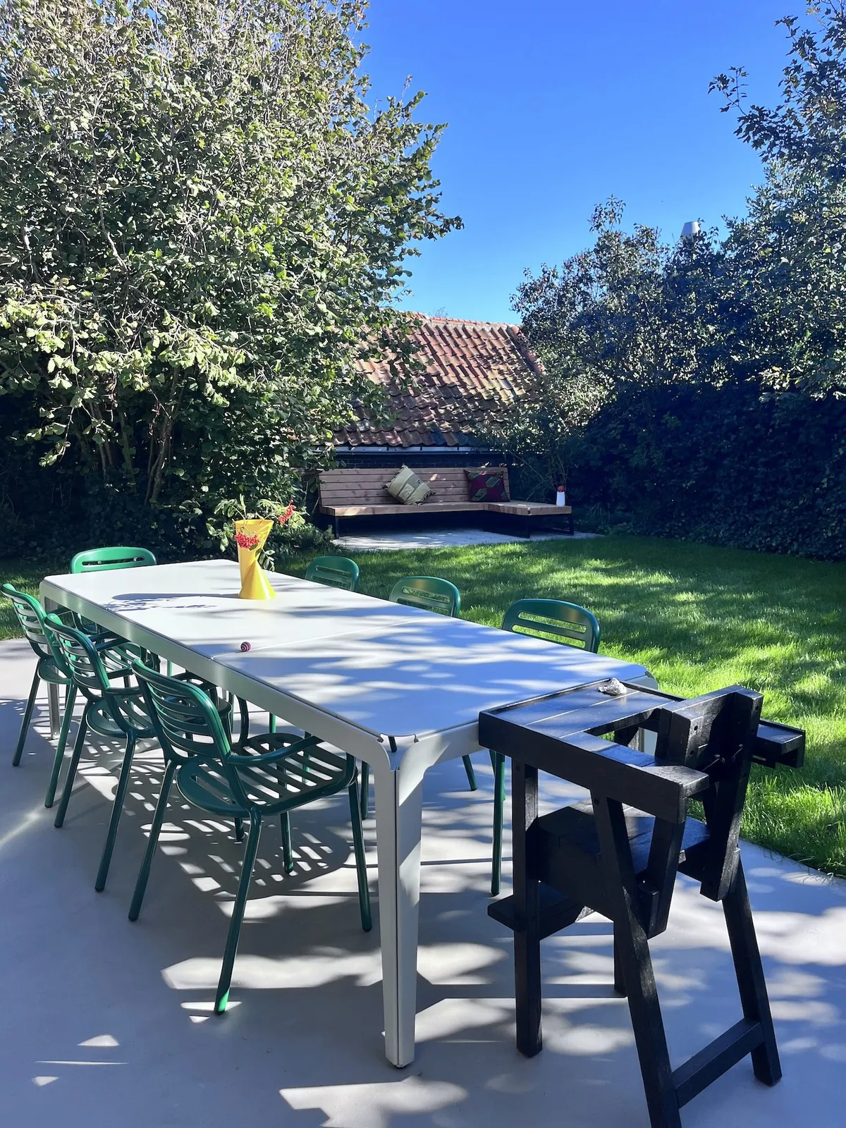 Lange tuintafel op het terras onder de bomen